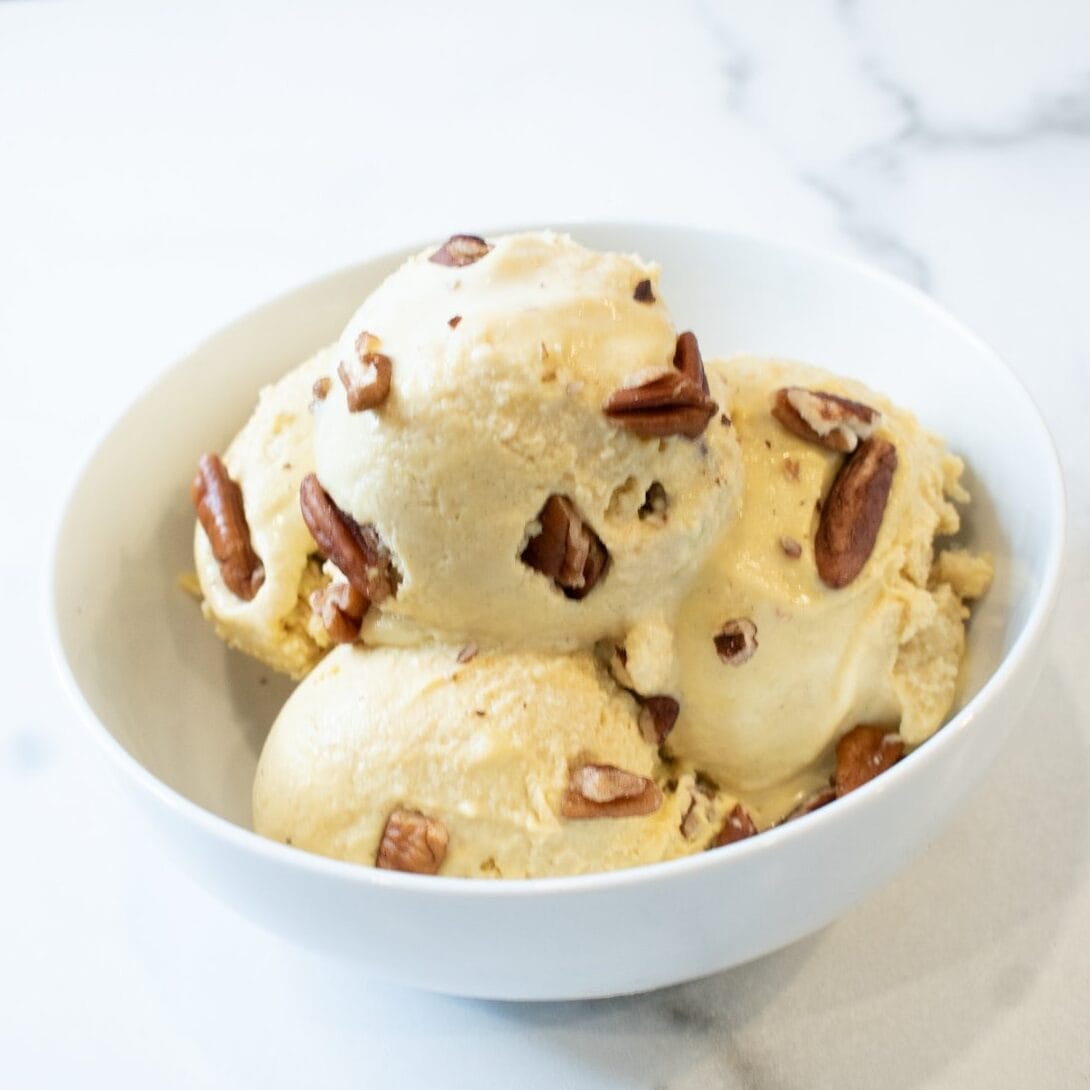 Delicious homemade nut ice cream with crunchy pecans in a white bowl.
